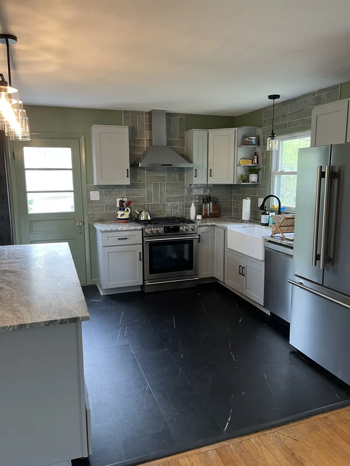Remodeled kitchen with white cabinets, farmhouse sink, and tile backsplash