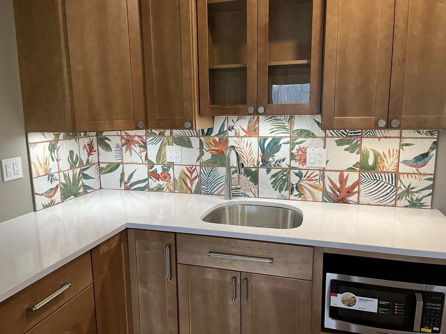 Kitchen with custom botanical tile backsplash and wood cabinets